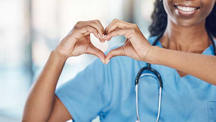 A doctor or nurse making a heart shape with their hands A doctor or nurse making a heart shape with their hands